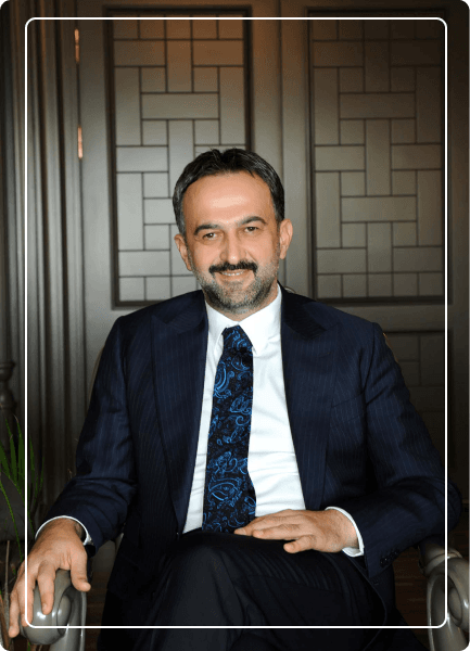Halil İbrahim Yılmaz koltuğun üzerinde gülümseyerek poz veriyor
